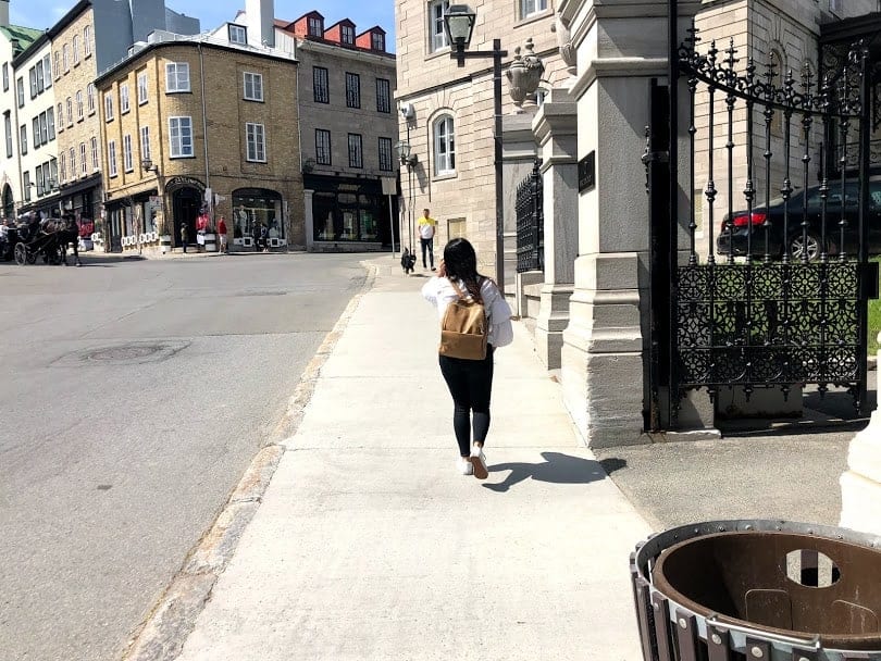 girl in white shirt and black pants walking in Quebec City, Canada