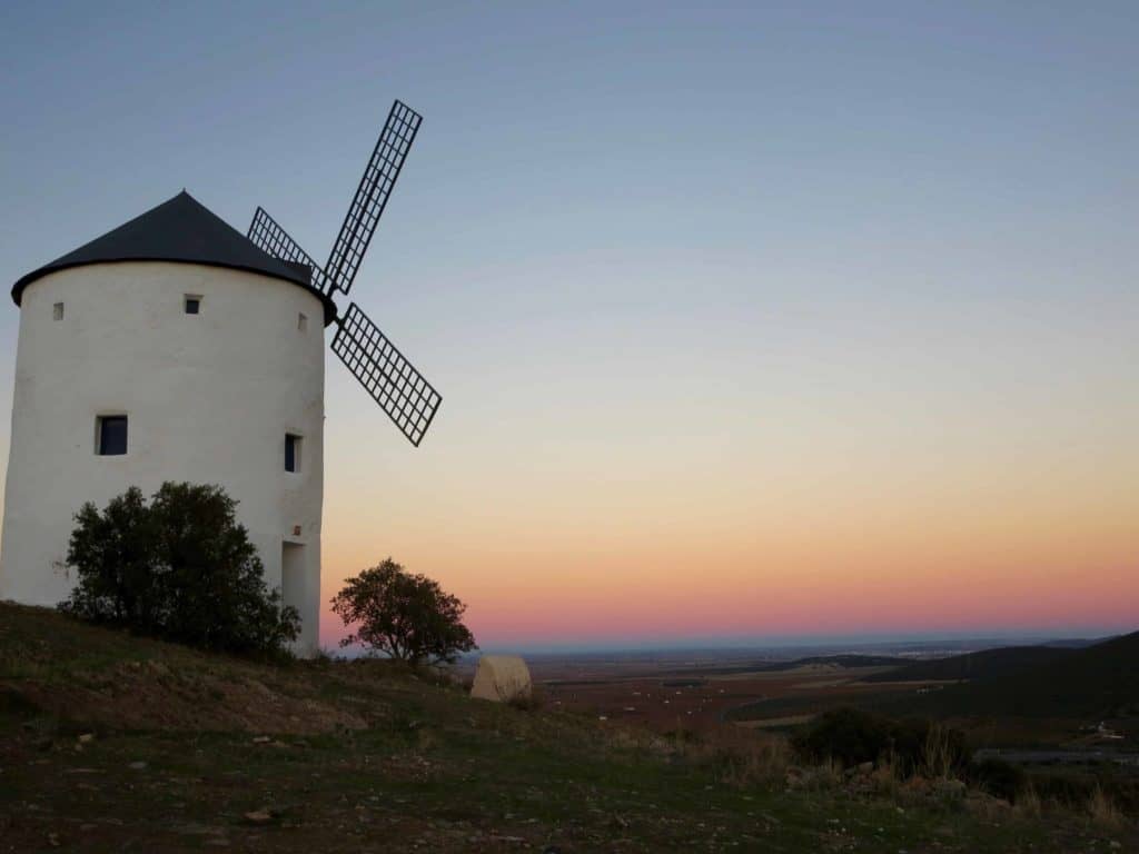 white windmills on a hill sunset