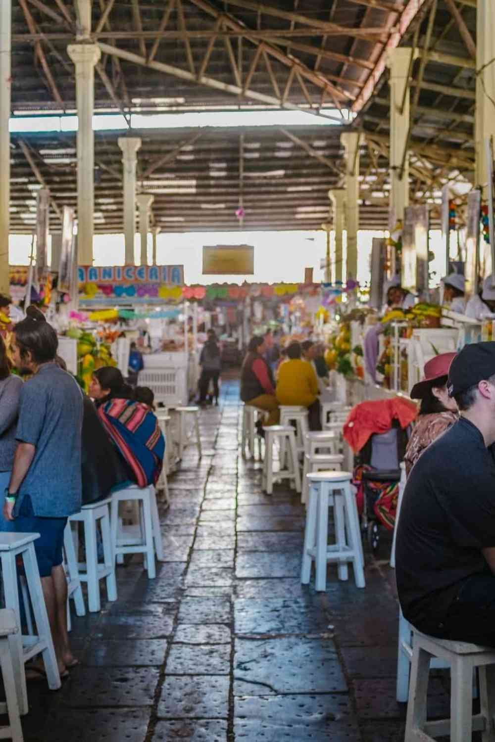 people enjoying food inside a typical food market in Peru