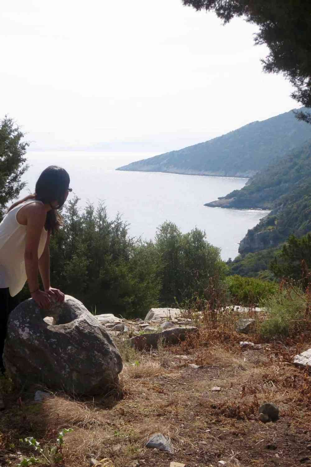 girl looking at the sea from the cliffs in greece