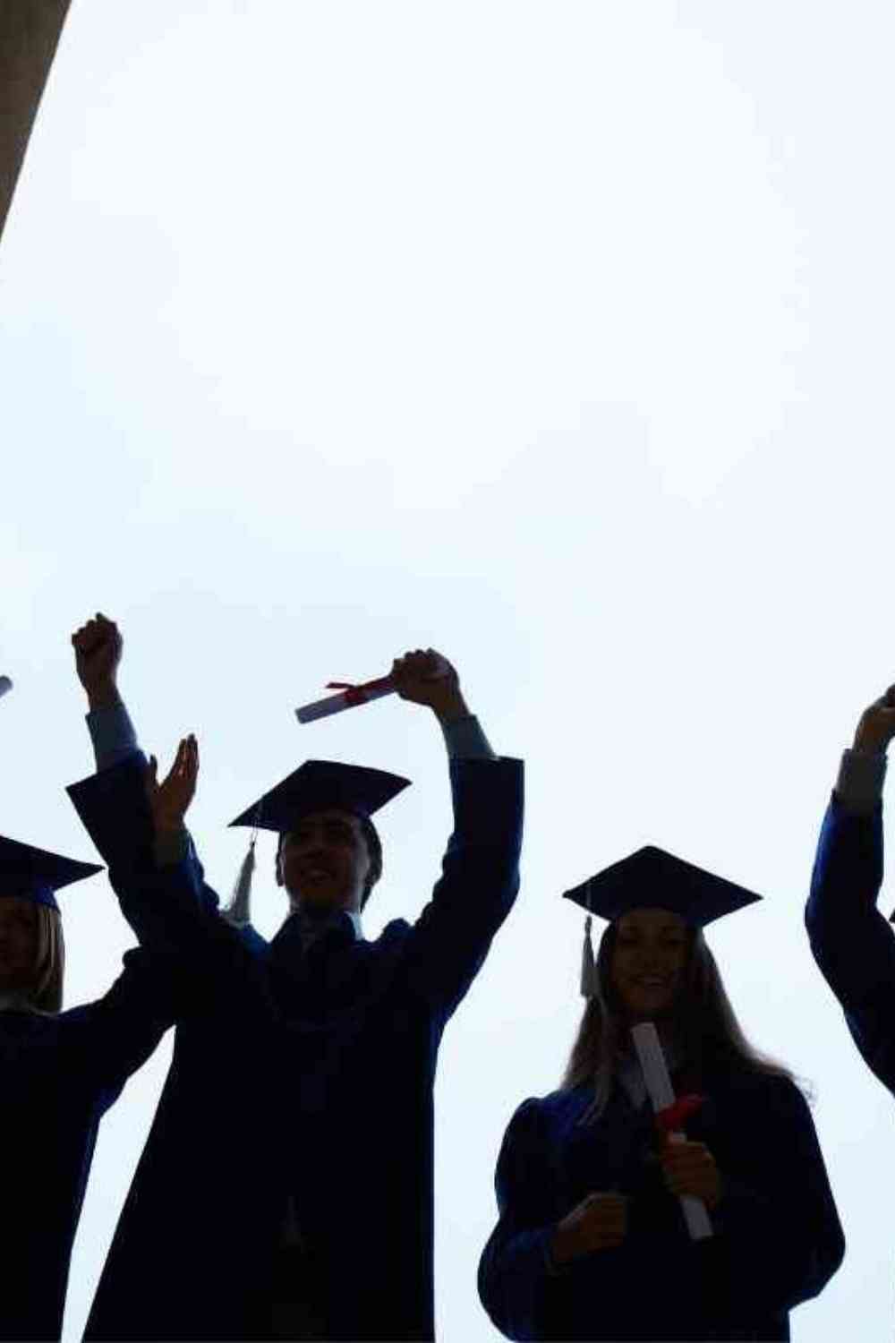 silhouette of students graduating college with diplomas in their hands