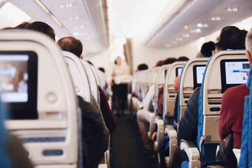 inside a plane looking at the back of seats and the airplane aisle