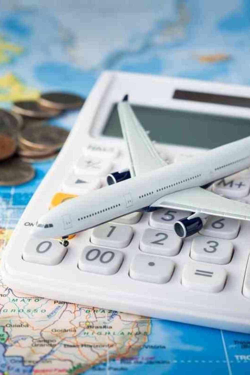 airplane toy on top of a calculator with money on a map