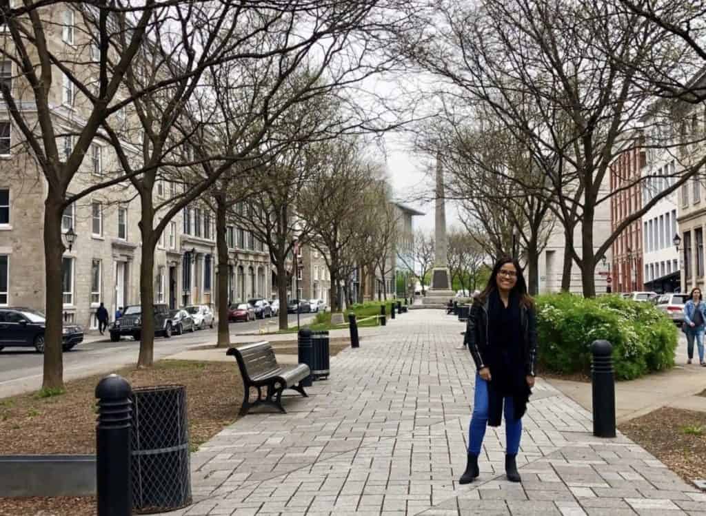 girl in black jacket and blue jeans standing in Montreal, Canada street
