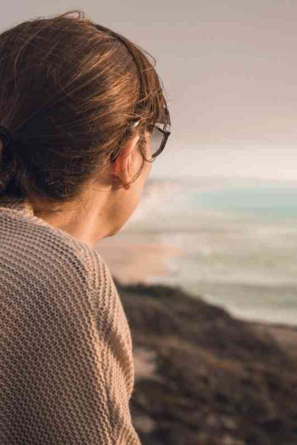 girl looking at nature from a mountain at sunset