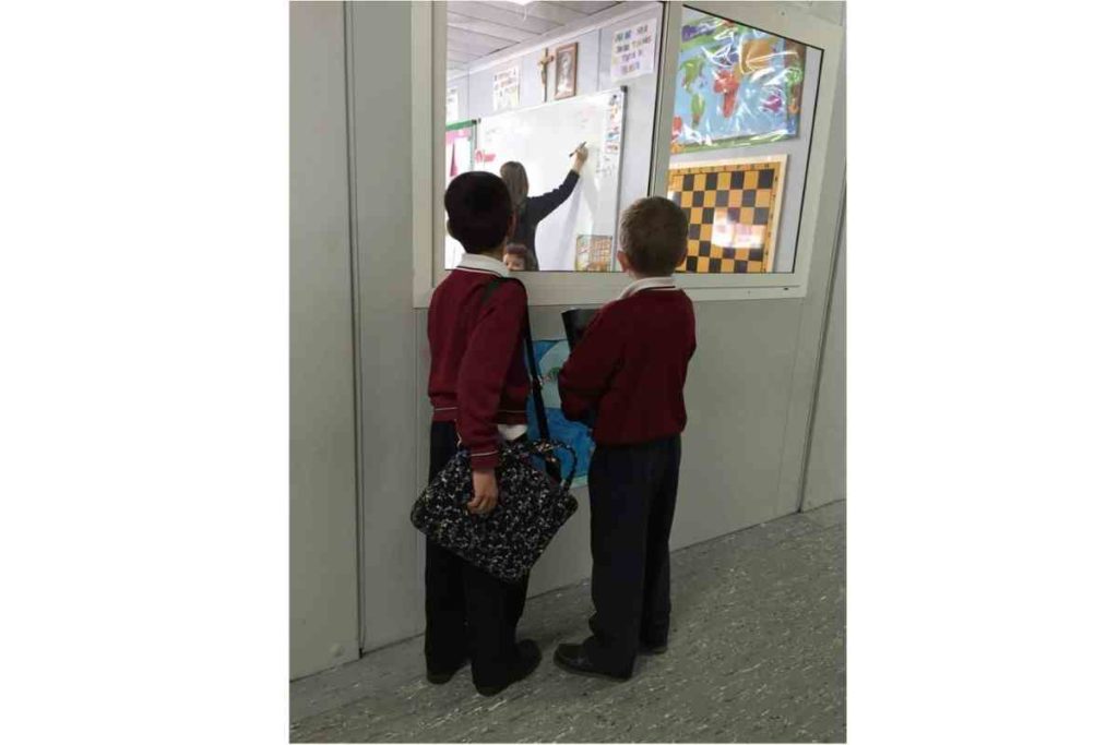 students in spain carrying books and computer in school