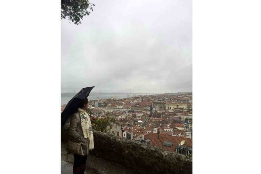 girl with black umbrella looking at Lisbon, Portugal from Castelo de Jorge