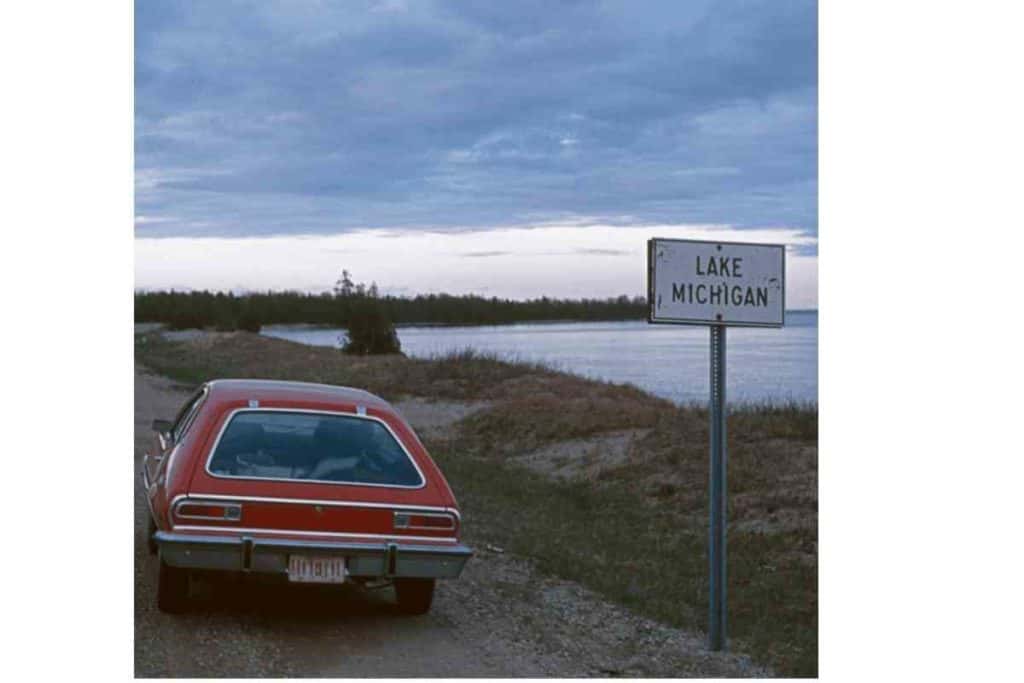 red car parked next to lake michigan