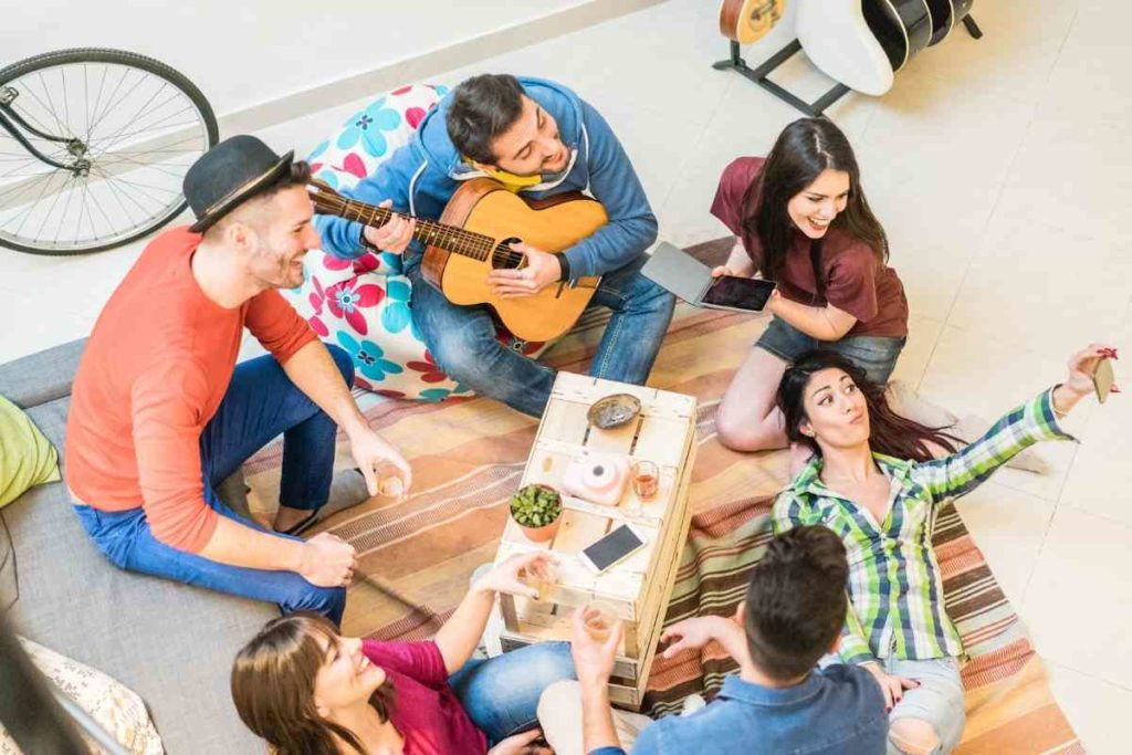 friends hanging out together laughing and playing music