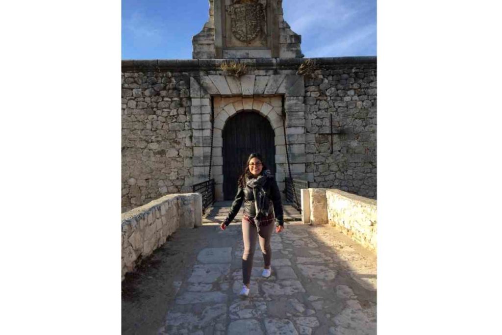 ni de aqui ni de alla girl with black jacket standing next to an abandoned castle in Chinchon, Madrid, Spain
