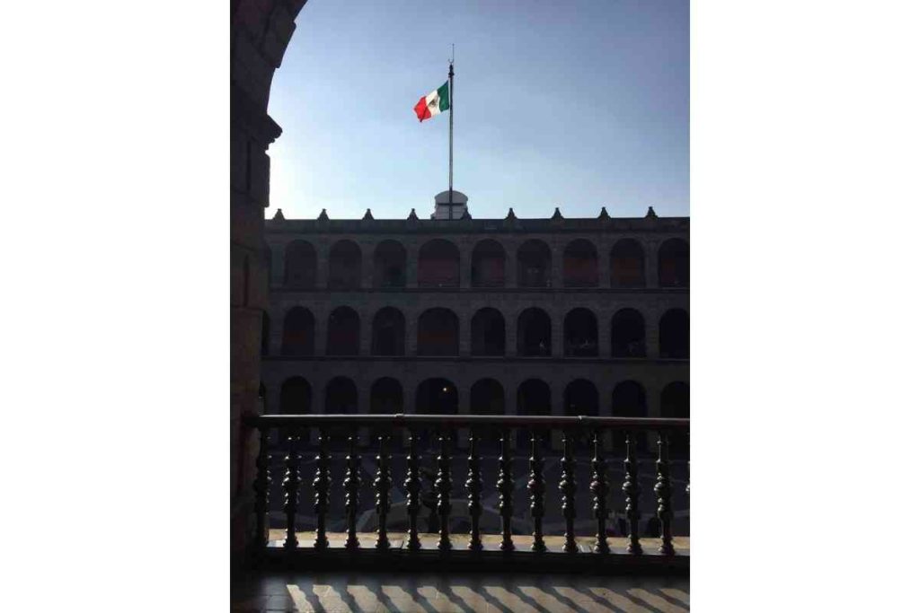the Mexican flag waving over the National Palace