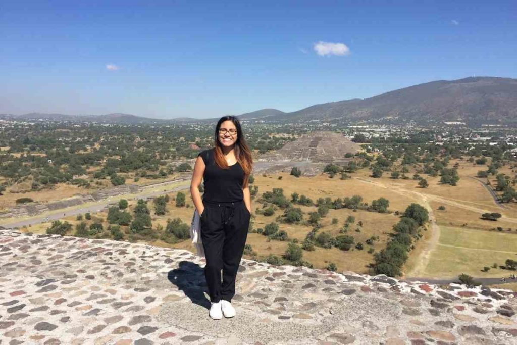 girl standing on top of the pyramid of the sun in Teotihuacan in Mexico City