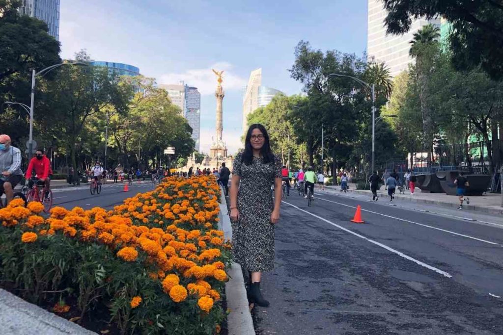 Girl in dress standing on Reforma Avenue with the Angel of Independence behind her in the fall 
