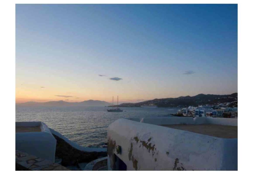 Mykonos, Greece sunset with boat and white houses