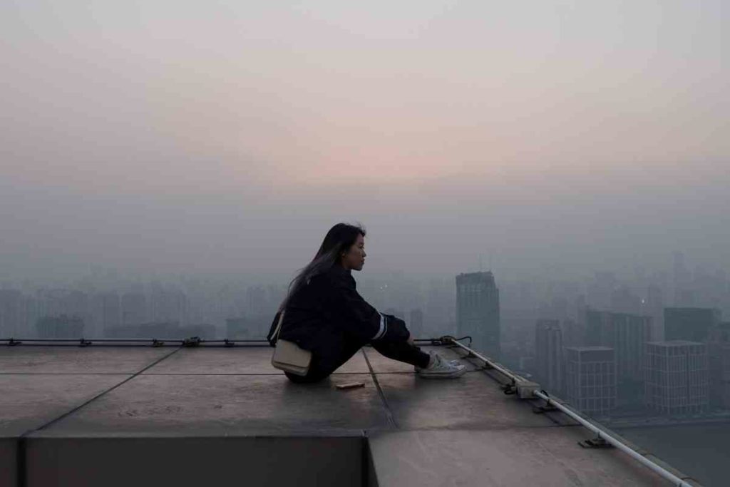 girl sitting on a rooftop in the city