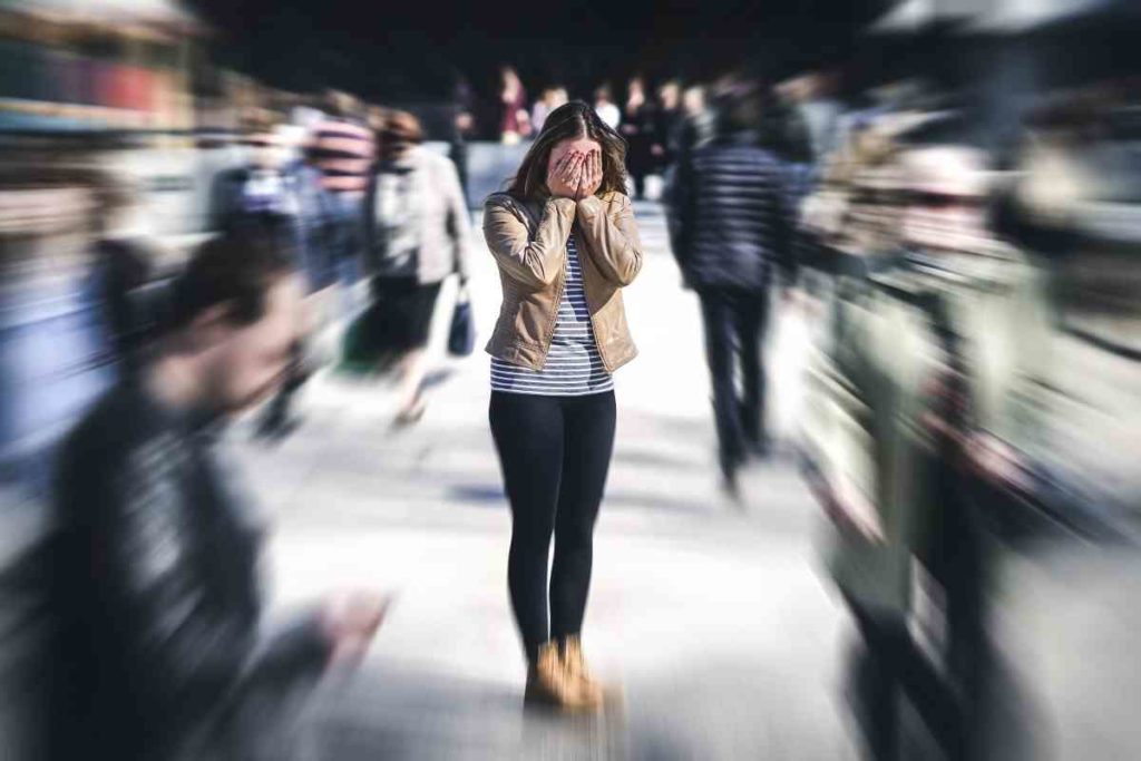 scared girl in the middle of a city covering her eys