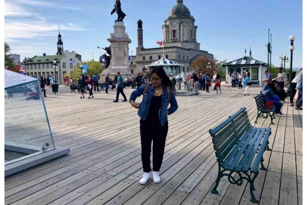 girl with glasses with jean jacket looking down in quebec city, canada