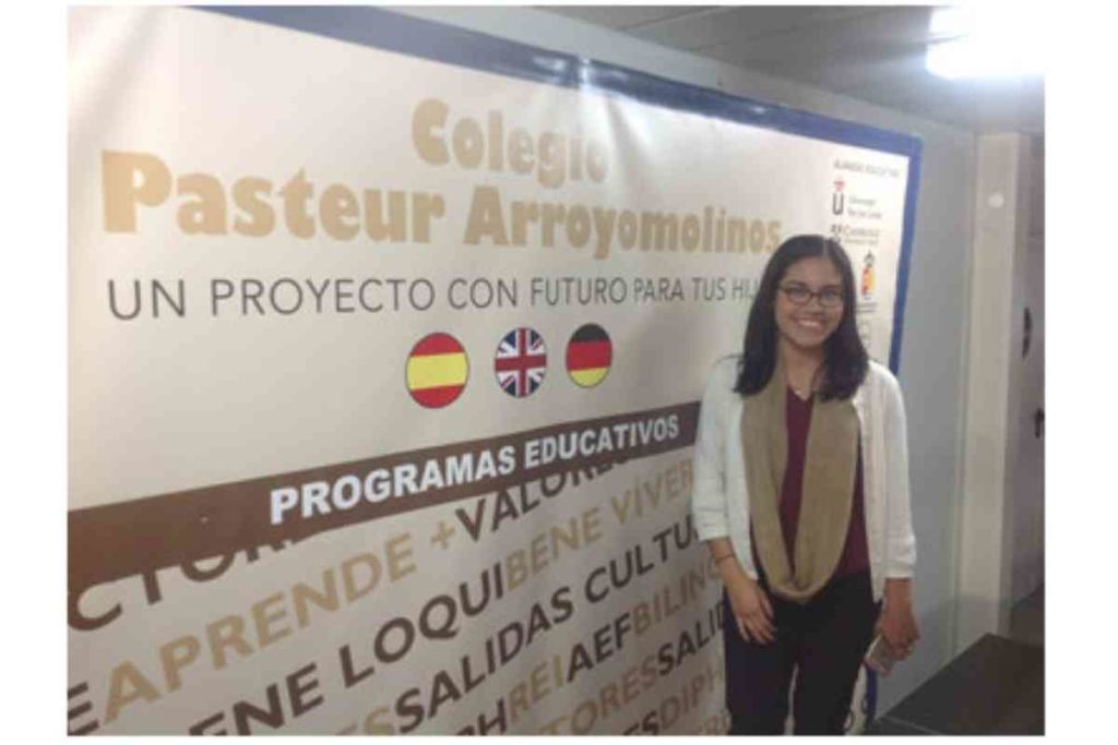 girl with glasses and black hair standing inside Spanish school in madrid, spain