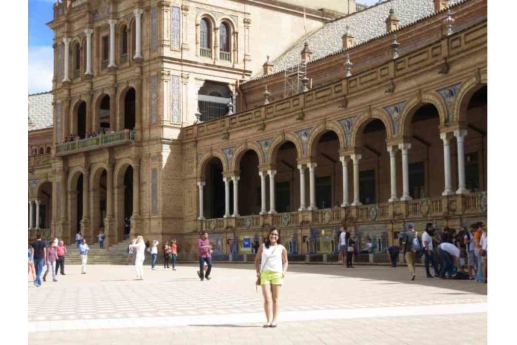 girl with green shorts and white shirt standing in plaza españa seville, Spain 