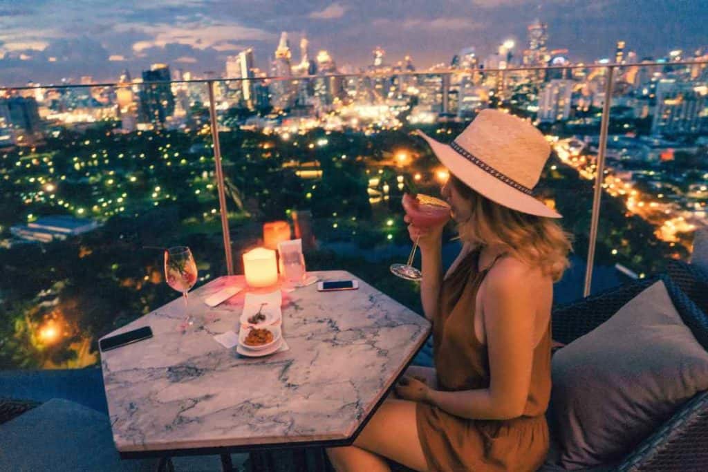 Best Safety Tips as a Solo Latina Traveler
girl going out and drinking a cocktail on a rooftop over the city at night