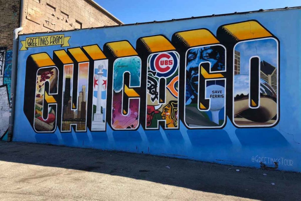 A vibrant and colorful mural titled 'Greetings from Chicago' displayed on an urban wall, featuring the letters of 'CHICAGO' filled with iconic symbols and landmarks. The images within the letters include a hot dog, the Chicago flag, the Cubs logo, graffiti art, a portrait of Ferris Bueller, and cityscapes including the Willis Tower. This mural represents the city's rich cultural scene and is a great photo opportunity for solo travelers exploring Chicago, highlighting the city's safety and numerous activities for individuals.