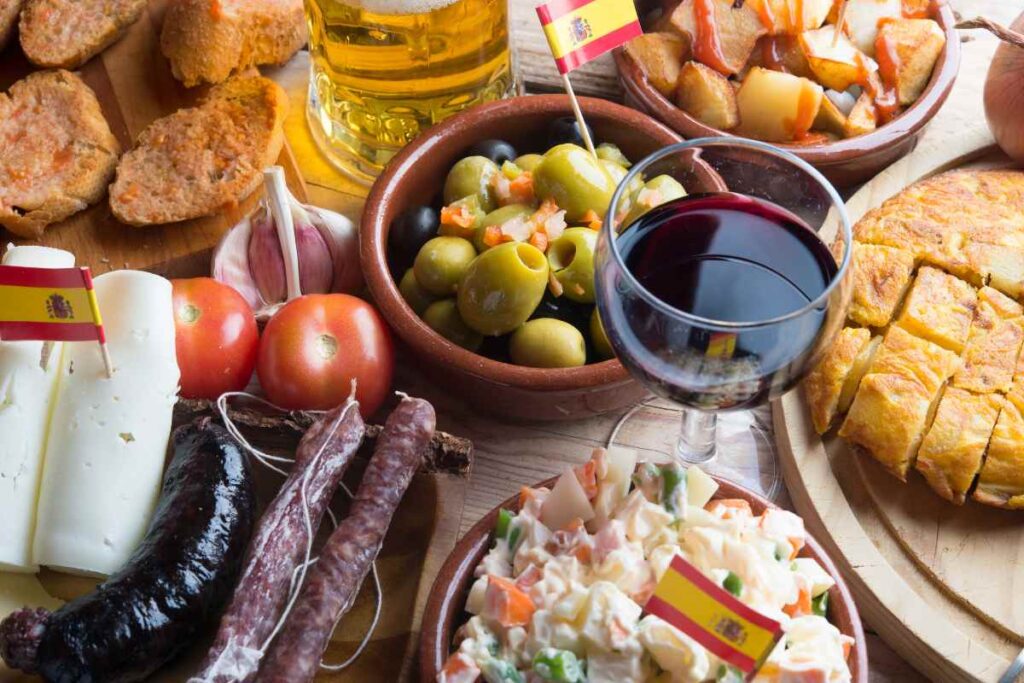 Traditional Spanish tapas spread with wine, cheese, olives, tortilla española, and chorizo—must-try bites for your Madrid bucket list.